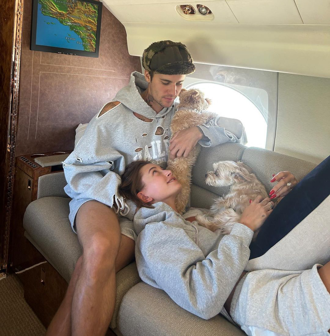 Hailey Bieber allongée sur les genoux de Justin Bieber dans un jet privé avec deux chiens